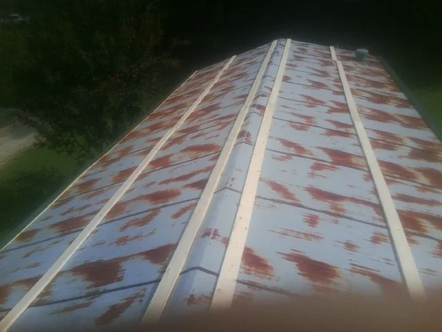 Rusted metal roof panels with new wood purlins before replacement — Storm Damage Roof Repair in Massey by Roofing Brothers