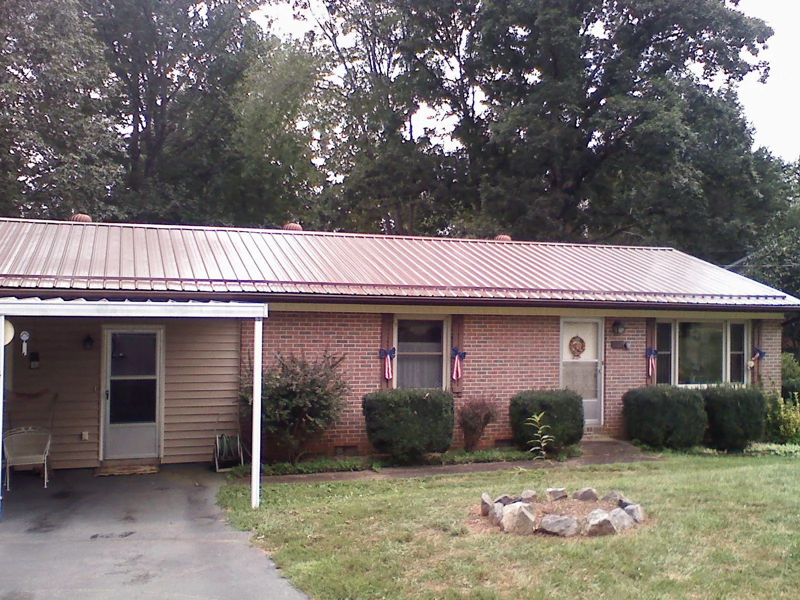 Bronze metal roof and carport on a brick ranch home — Roof Repair work by our crew in Massey