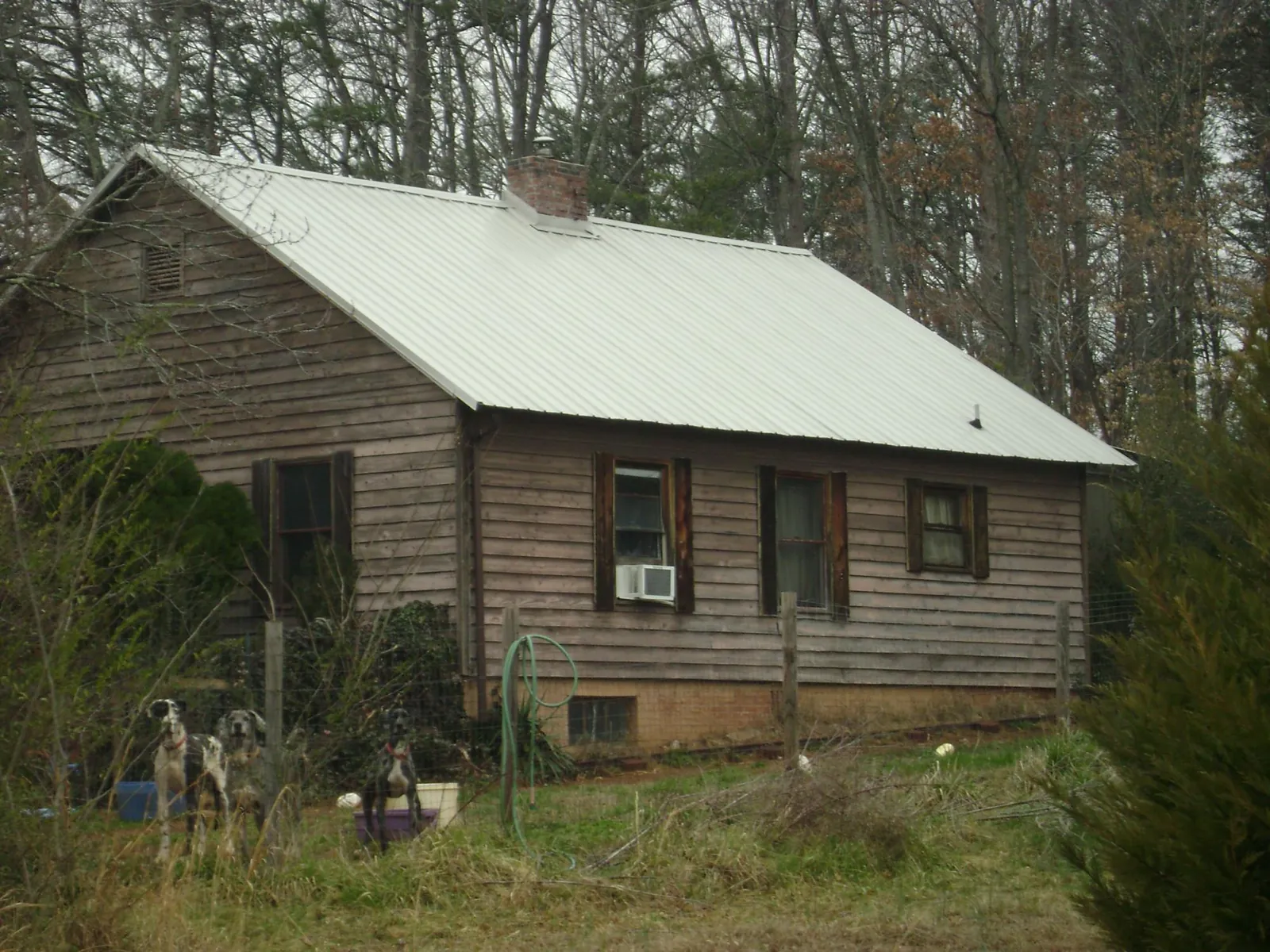 White metal roof on an old wood sided farmhouse, from a Metal Roof Installation job in Massey